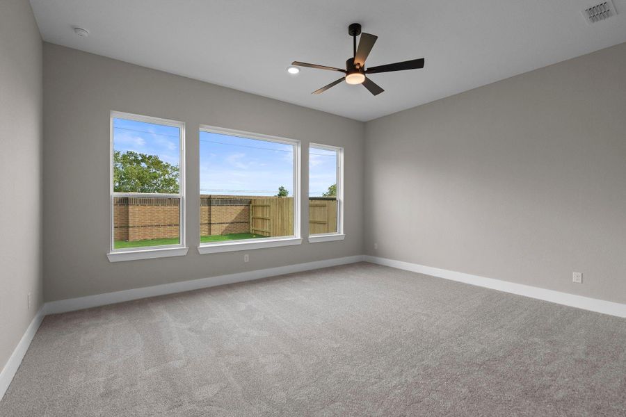 Spacious main bedroom with a view of the private back yard