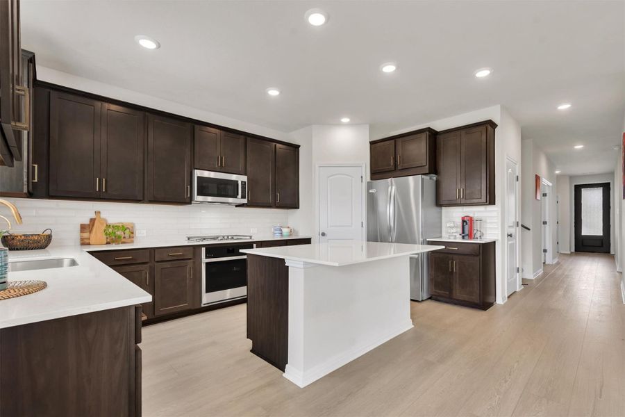 Big beautiful and bright kitchen with gorgeous quartz counters, designer backsplash, stainless cooking and gas range Big beautiful and bright kitchen with gorgeous quartz counters, designer backsplash, stainless cooking and gas range