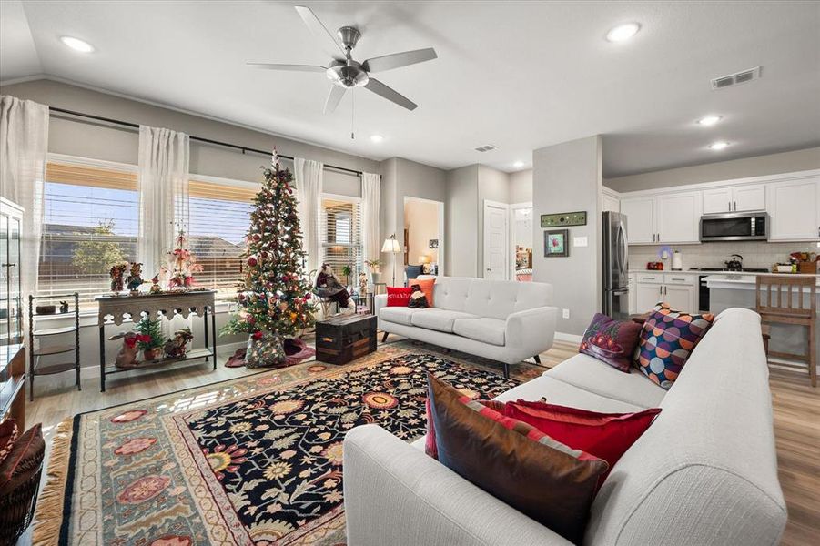 Living room featuring light wood-style flooring, ceiling fan, and recessed lighting Living room featuring light wood-style flooring, ceiling fan, and recessed lighting