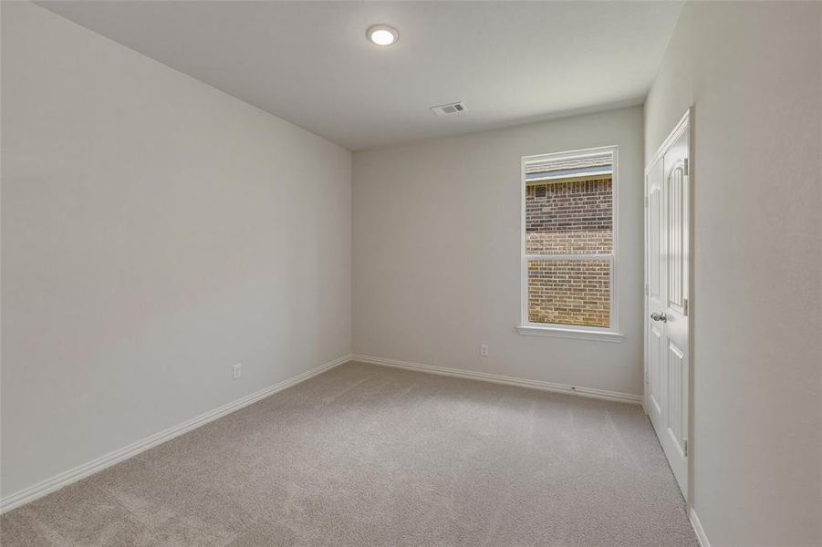 Neutral-toned room featuring a single window and recessed lighting Neutral-toned room featuring a single window and recessed lighting