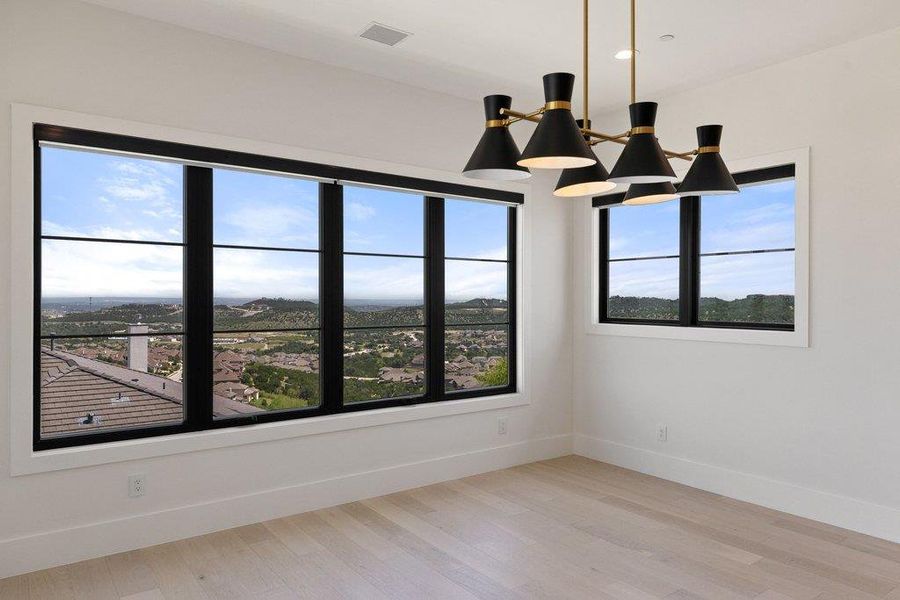 Floor-to-ceiling windows frame a panoramic vista of the surrounding landscape, providing an awe-inspiring backdrop to this bright space.
