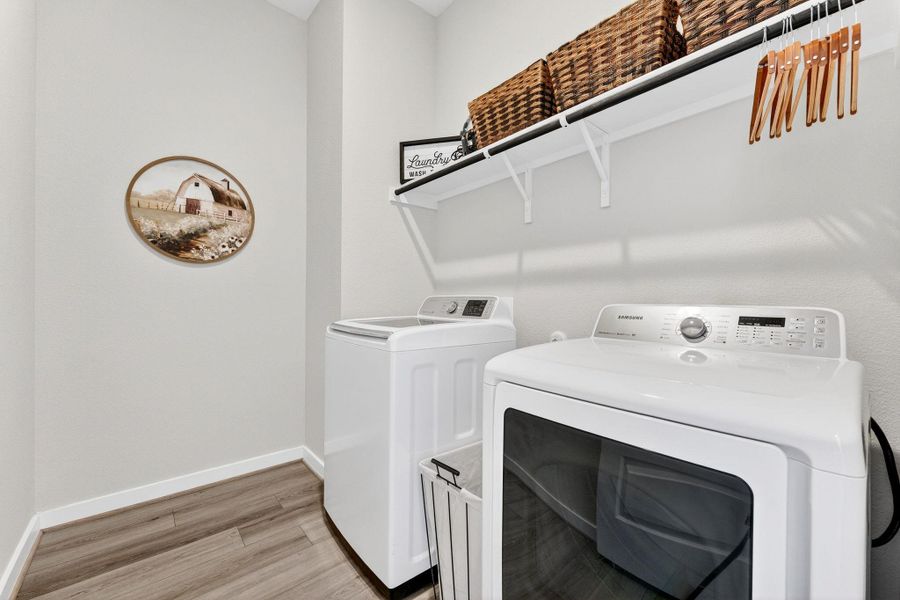 Large laundry room with light wood-style floors and independent washer and dryer
