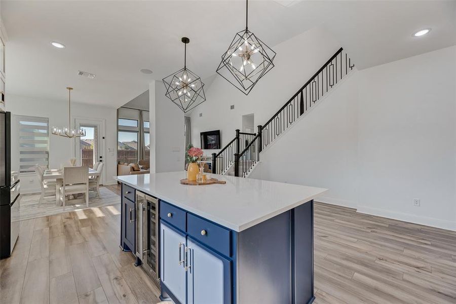 Kitchen featuring blue cabinetry, recessed lighting, hanging light fixtures, a chandelier, and a kitchen island