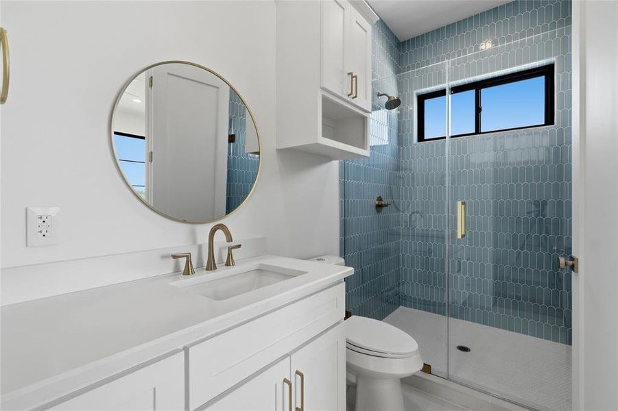 Bathroom vanity with a round framed mirror and brushed gold-tone faucet