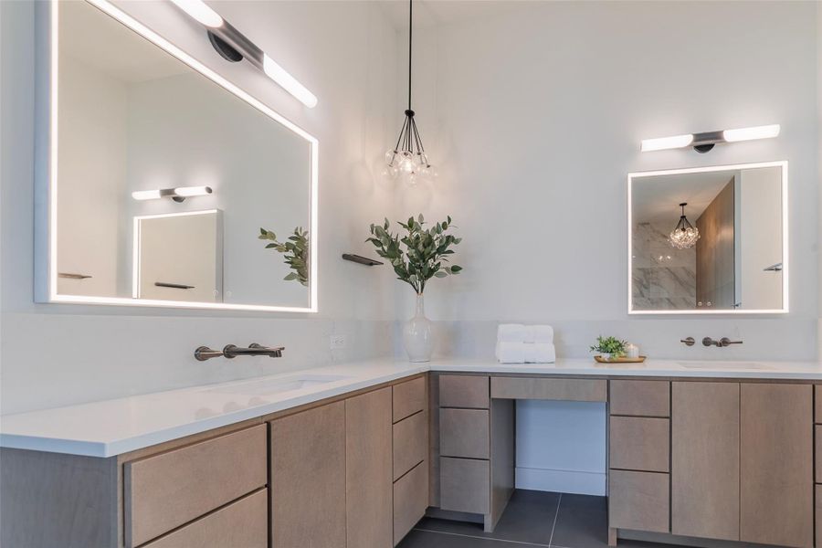 Full bath with double vanity and dark tile patterned flooring