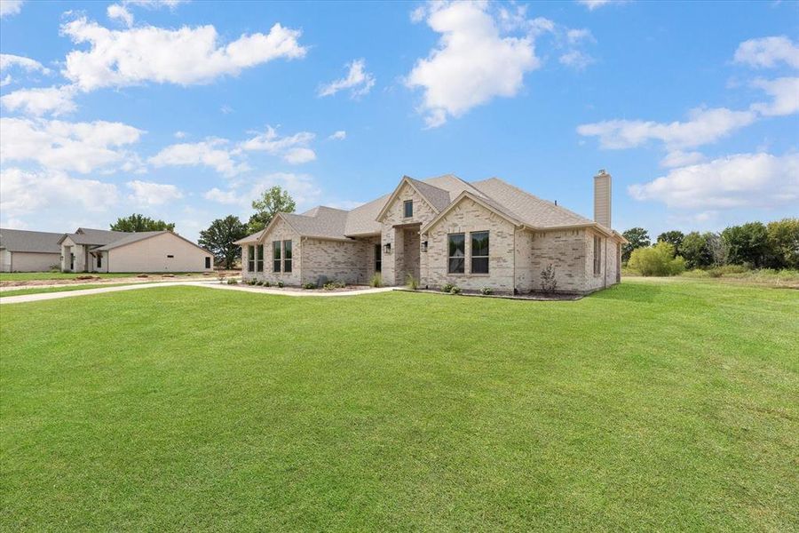 French country inspired facade with a front yard