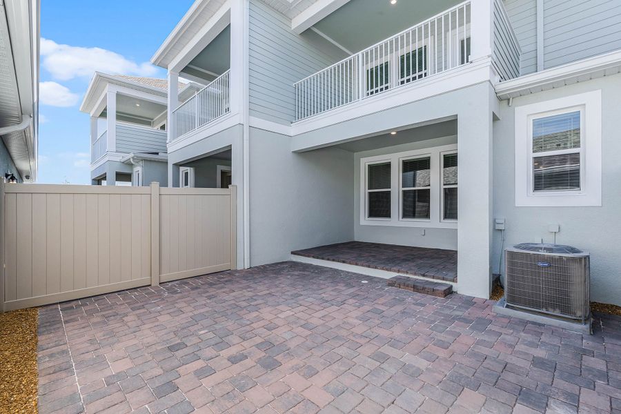 Exterior details and patio area of a home in Harvest at Ovation - Townhomes, Winter Garden (Image 16).