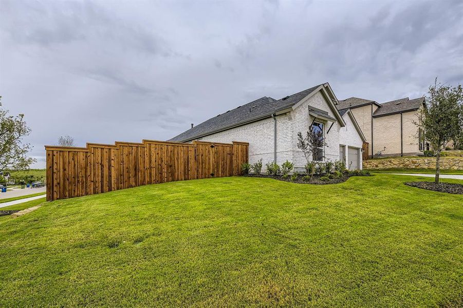 View of property exterior with brick siding, a garage, and a shingled roof
