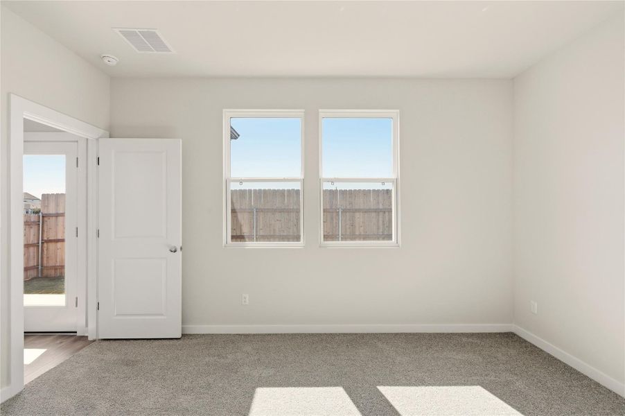 Unfurnished bedroom with light colored carpet and baseboards