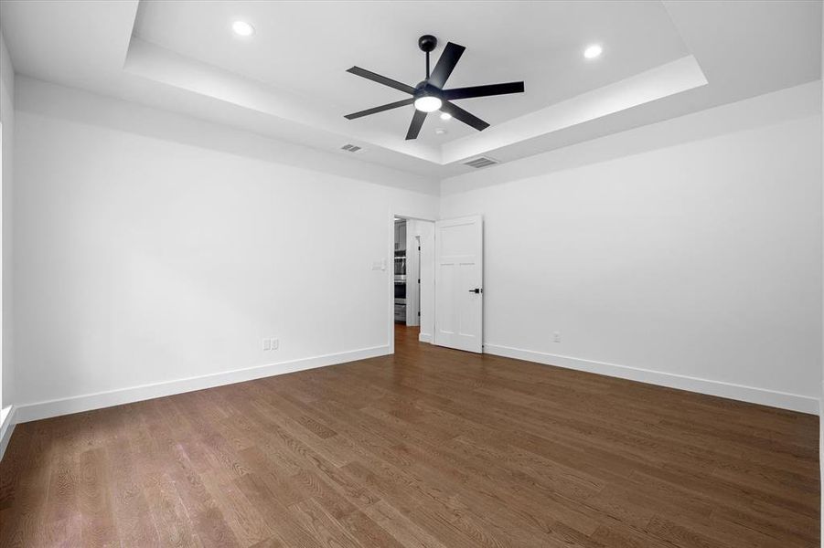 Unfurnished room featuring a tray ceiling, dark wood finished floors, recessed lighting, and a ceiling fan Unfurnished room featuring a tray ceiling, dark wood finished floors, recessed lighting, and a ceiling fan