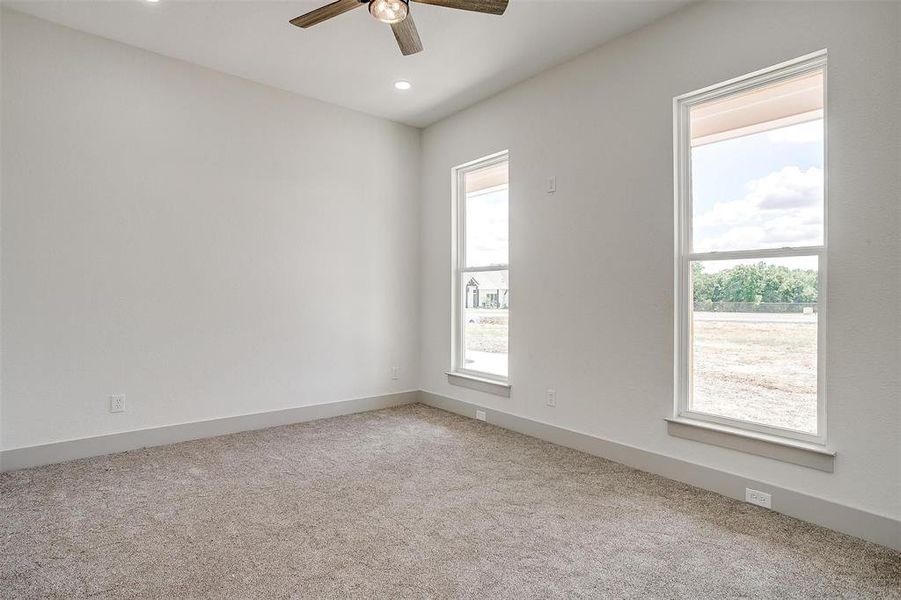 Unfurnished room with light colored carpet and ceiling fan