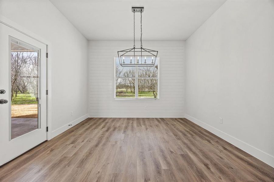 Unfurnished dining area with wood finished floors and baseboards Unfurnished dining area with wood finished floors and baseboards