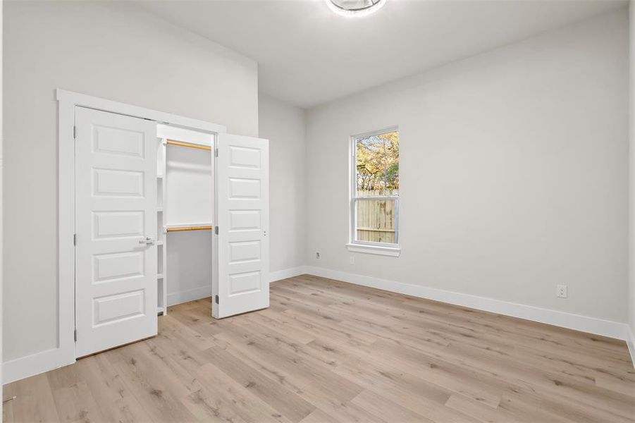 Unfurnished bedroom with light wood-type flooring and a closet