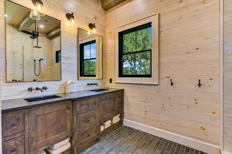 Bathroom featuring double vanity and wood walls