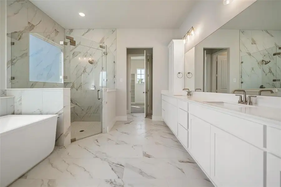 Bathroom with a marble finish shower, double vanity, a soaking tub, light marble finish flooring, and recessed lighting Bathroom with a marble finish shower, double vanity, a soaking tub, light marble finish flooring, and recessed lighting