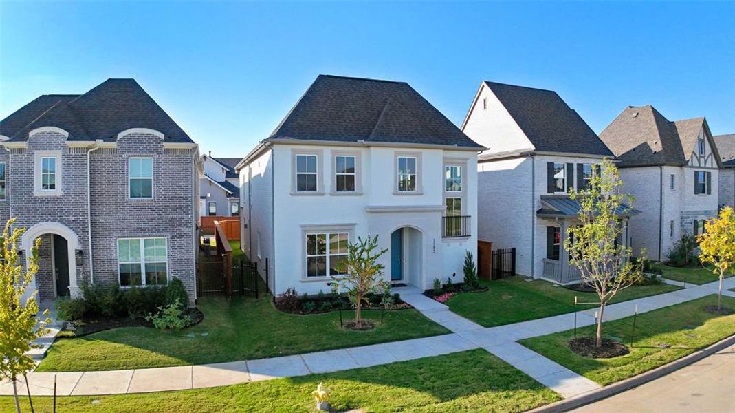 French country home featuring a residential view, brick siding, and roof with shingles French country home featuring a residential view, brick siding, and roof with shingles
