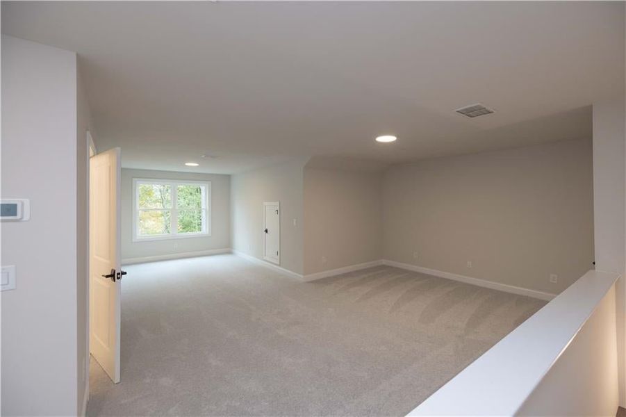Spare room featuring light colored carpet and recessed lighting