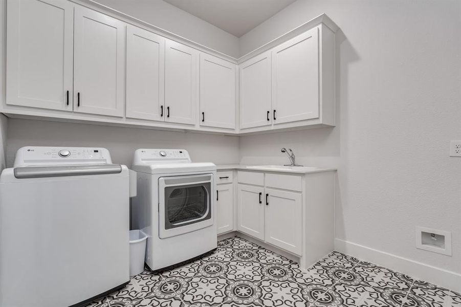 Laundry area featuring sink, cabinets, and independent washer and dryer