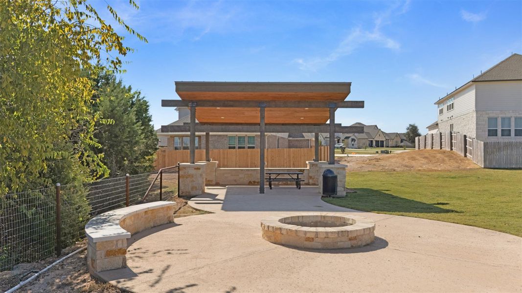 A welcoming communal patio area features a covered gathering space and a stone fire pit, ideal for outdoor enjoyment. A welcoming communal patio area features a covered gathering space and a stone fire pit, ideal for outdoor enjoyment.