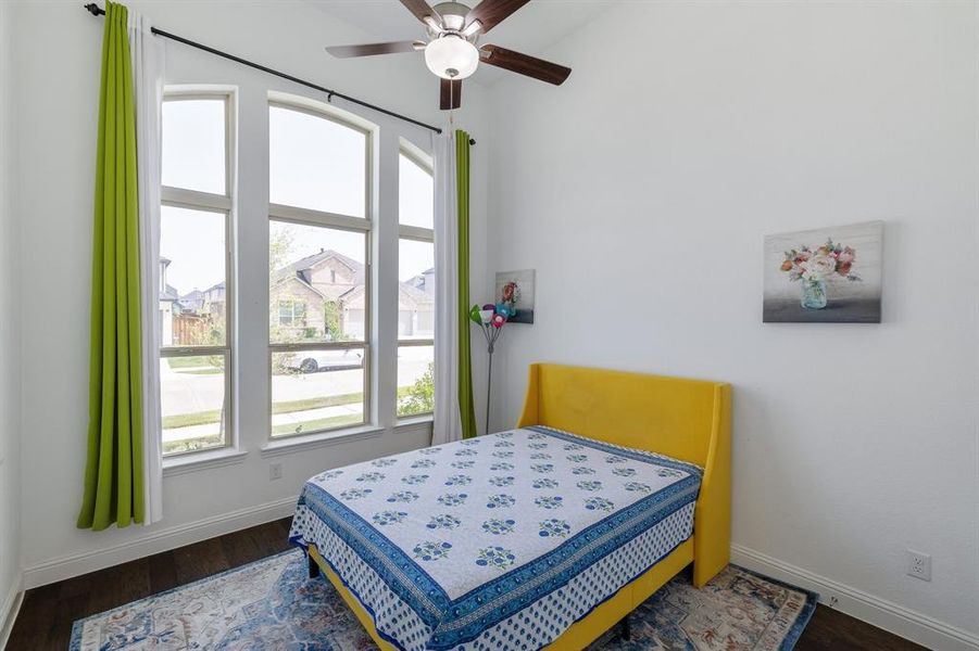 Bedroom with a ceiling fan, baseboards, and wood finished floors