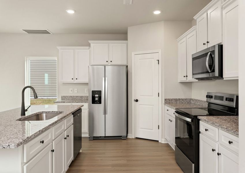 This kitchen has wood cabinets and granite countertops