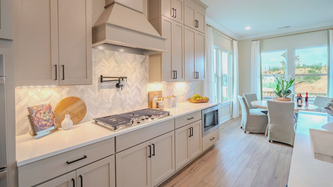 Kitchen with tile backsplash, quartz countertops, and pendant lighting Kitchen with tile backsplash, quartz countertops, and pendant lighting