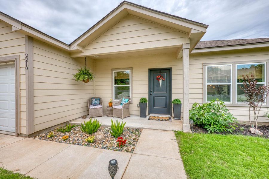 Inviting covered front porch with a dark-paneled entry door