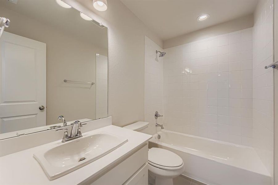 Bathroom with vanity, shower / bath combination, and recessed lighting
