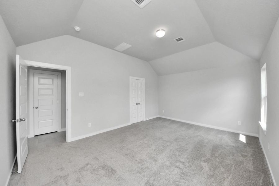 Escape and relax in the exquisite primary suite, a haven to unwind after a long day. The spacious room, located on first floor, boasts plush carpeting, soothing paint tones, high ceilings, and expansive windows adorned with privacy blinds. Sample photo of completed home with similar floor plan. Actual colors and selections may vary.