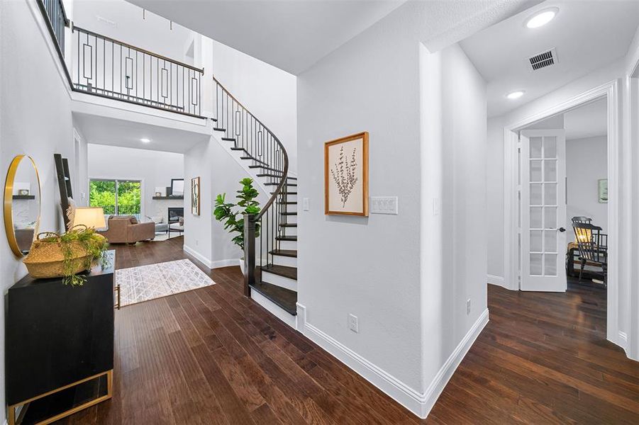 Foyer entrance featuring stairway, wood finished floors, recessed lighting, and a towering ceiling