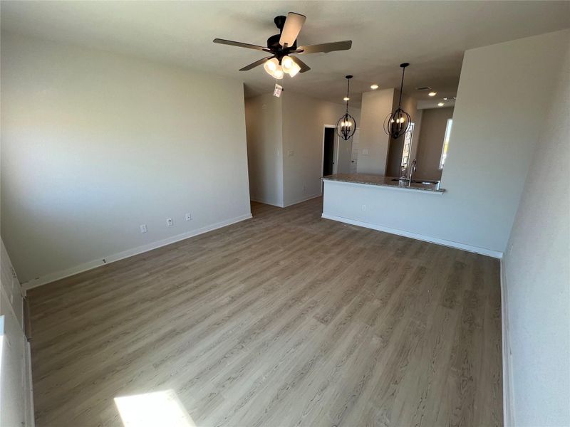 Unfurnished living room featuring light wood-style flooring, a ceiling fan, recessed lighting, and a chandelier