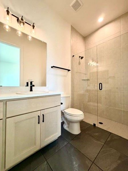 A well-lit primary bathroom features a spacious glass-enclosed shower and modern vanity. A well-lit primary bathroom features a spacious glass-enclosed shower and modern vanity.
