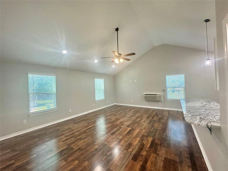 Upstairs Living room with an mini split wall unit, luxury vinyl plank flooring, ceiling fan, and lofted ceiling Upstairs Living room with an mini split wall unit, luxury vinyl plank flooring, ceiling fan, and lofted ceiling