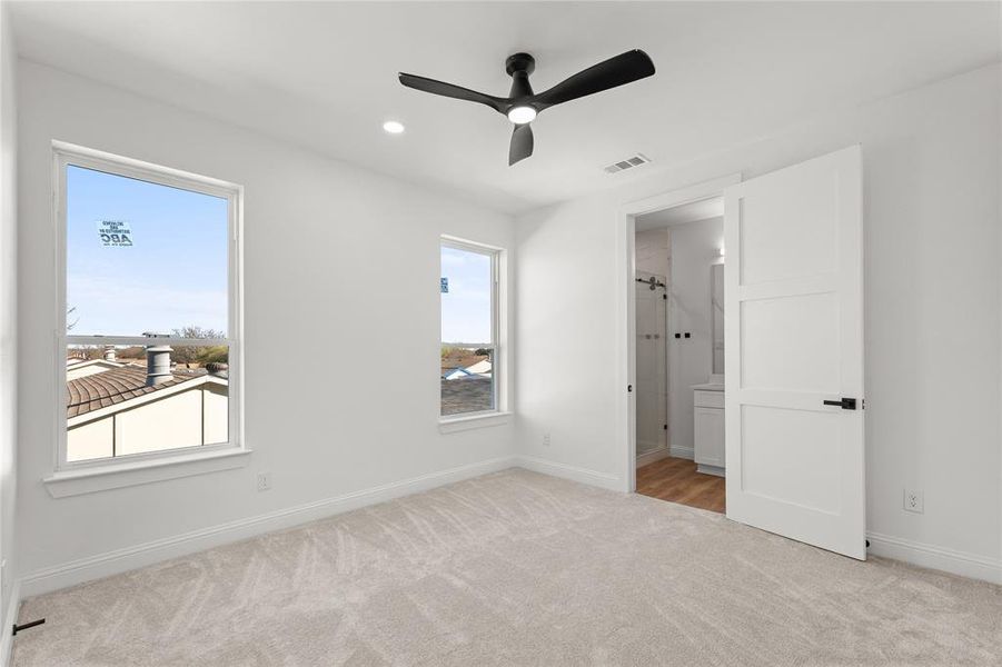 Unfurnished bedroom with light carpet, connected bathroom, ceiling fan, and recessed lighting
