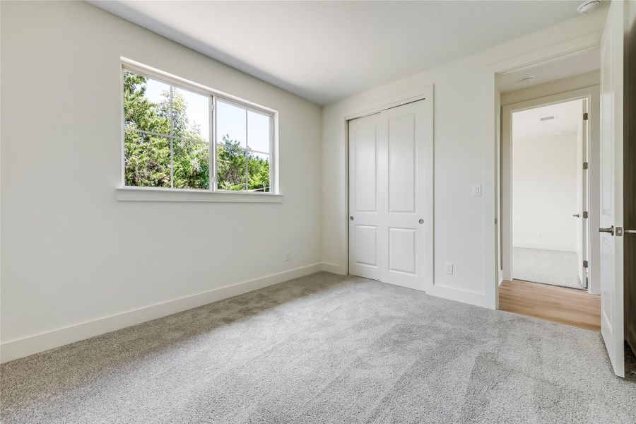 Unfurnished bedroom with light colored carpet and a closet