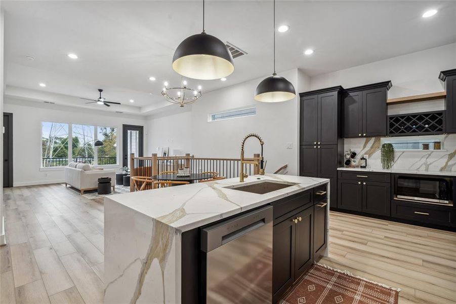 This open kitchen offers a direct view into the dining and living areas, with ample natural light that creates an inviting atmosphere for gathering