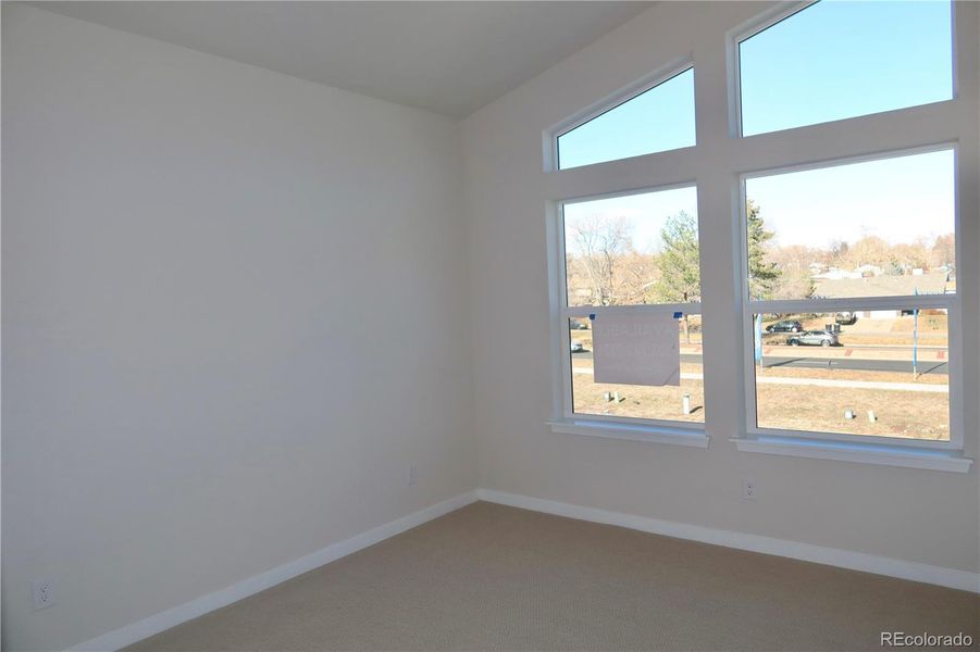 Bedroom 1 with walk-in closet, attached bath and high, slanted ceilings.
