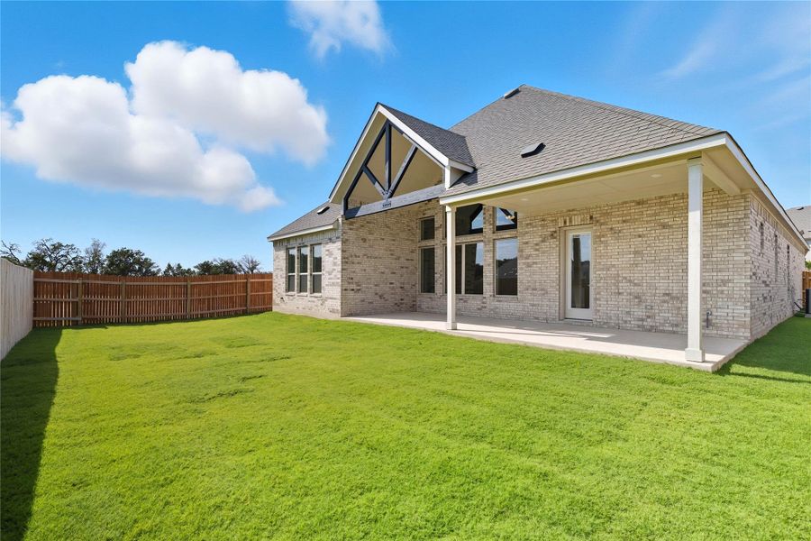 Back of property with brick siding, a patio, a fenced backyard, and a shingled roof Back of property with brick siding, a patio, a fenced backyard, and a shingled roof