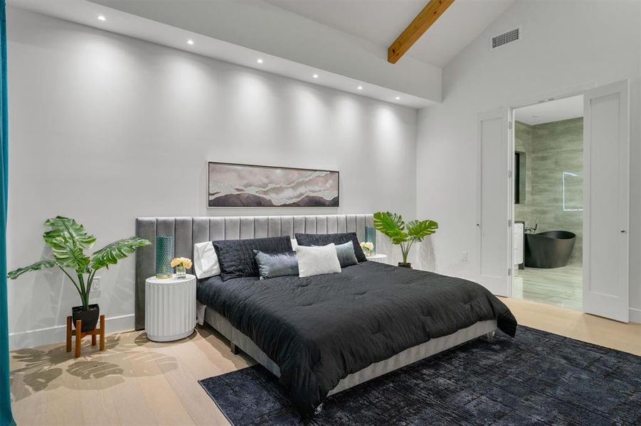 Bedroom with light wood-type flooring, lofted ceiling, ensuite bath, and recessed lighting Bedroom with light wood-type flooring, lofted ceiling, ensuite bath, and recessed lighting