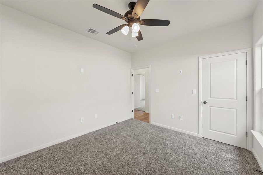 Unfurnished bedroom with carpet and a ceiling fan Unfurnished bedroom with carpet and a ceiling fan