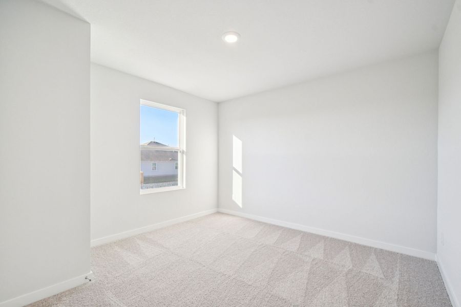 A room with a carpet and a window.