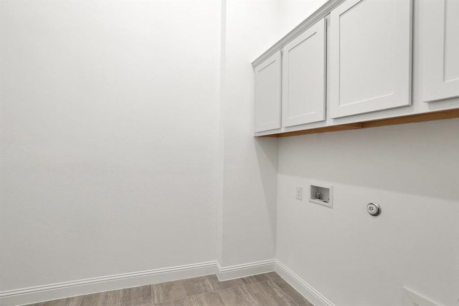 Laundry room featuring cabinets and tile flooring