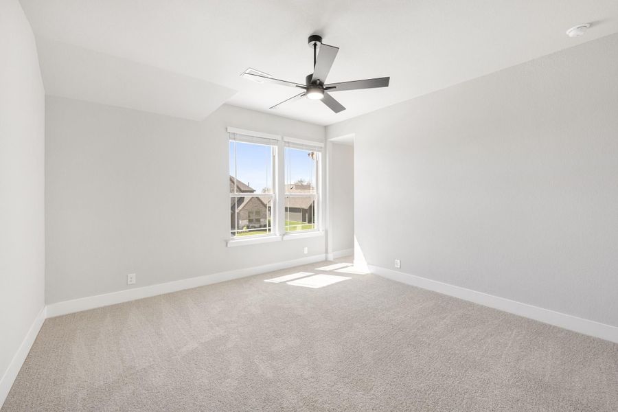 Empty bedroom with beige carpet, ceiling fan, and double window with natural light Empty bedroom with beige carpet, ceiling fan, and double window with natural light