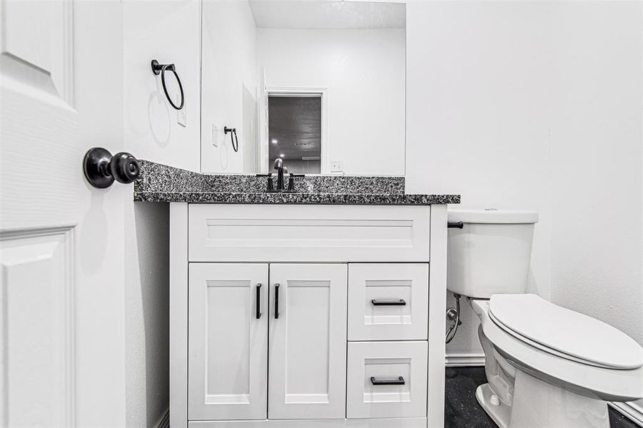 Bathroom featuring toilet, vanity, and tile patterned floors