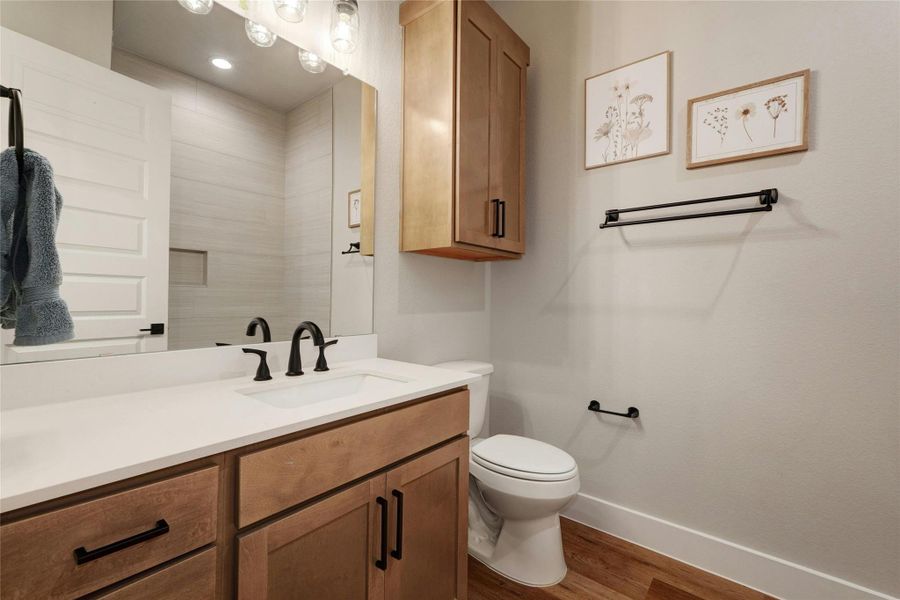 Bathroom vanity with a white countertop and integrated sink, complemented by a matte black faucet