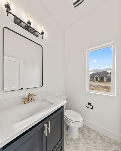 Bathroom featuring a dark wood-finish vanity with a white countertop and integrated sink, a rectangular mirror, and a three-light fixture with exposed bulbs