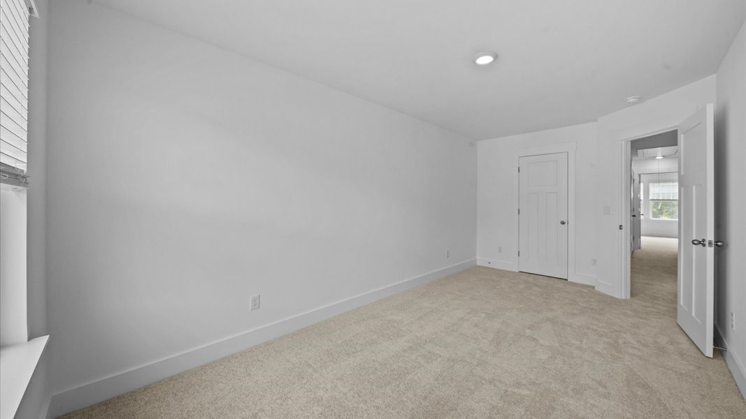 First-rate secondary bedroom with a spacious walk-in closet and elegant carpeted flooring at Ransdell Pointe