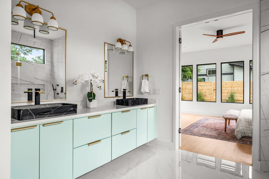Marble-tiled floors lead to a dual-vanity bathroom featuring sleek cabinetry and golden accents. Marble-tiled floors lead to a dual-vanity bathroom featuring sleek cabinetry and golden accents.