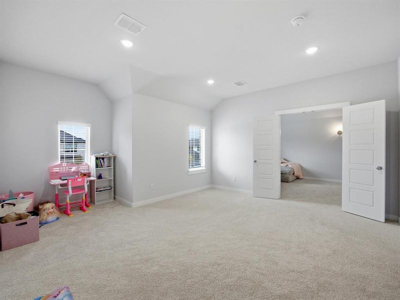 Recreation room featuring light carpet, plenty of natural light, recessed lighting, and lofted ceiling