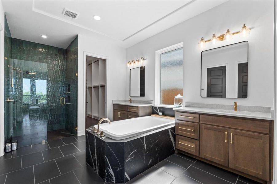 Bathroom featuring a stall shower, a garden tub, two vanities, dark tile patterned flooring, and recessed lighting Bathroom featuring a stall shower, a garden tub, two vanities, dark tile patterned flooring, and recessed lighting